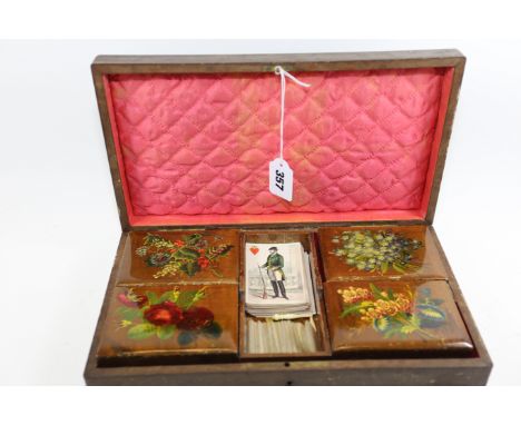 A LATE 19TH CENTURY CONTINENTAL FLORAL TRANSFER DECORATED GAMES BOX, the interior with four removable playing card boxes and 