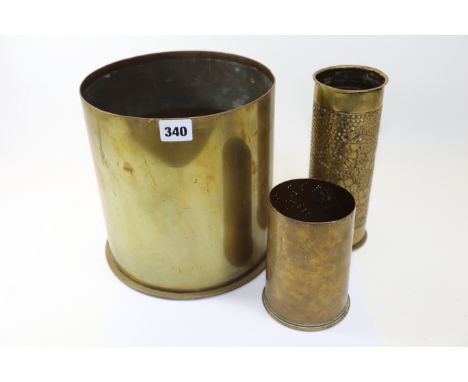 A LARGE 1917 BRASS SHELL CASE, 8 1/2 ins diameter, a trench Art DITTO and another. (3)   