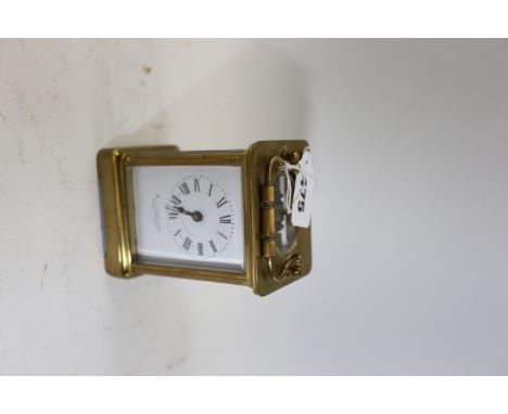 AN EARLY 20TH CENTURY BRASS 8 DAY CARRIAGE CLOCK with white enamel dial, 4 1/4 ins high.   
