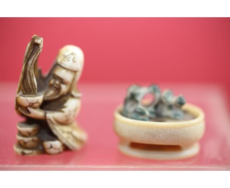 AN EARLY 20TH CENTURY JAPANESE CARVED IVORY NETSUKE of a seated bearded MAN with four bowls, signature to base, 1 1/2 ins hig