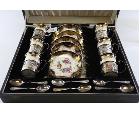 A SET OF SIX HAMMERSLEY PORCELAIN FLORAL DECORATED COFFEE CANS AND SAUCERS with pierced silver holders, Birmingham 1953 toget