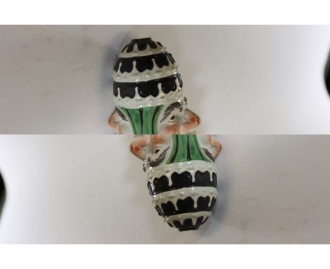 AN EARLY 19TH CENTURY PRATT-WARE POTTERY REVERSIBLE POPE AND DEVIL STIRRUP CUP with leaf decoration to the sides, lacks to fi