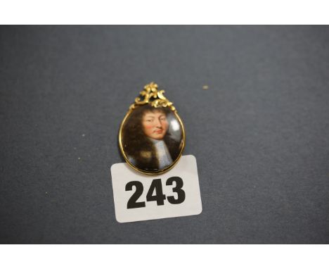 AN ANTIQUE OVAL ENAMEL PORTRAIT PENDANT, depicting a 17th Century Gentleman in a scroll top yellow metal mount.   