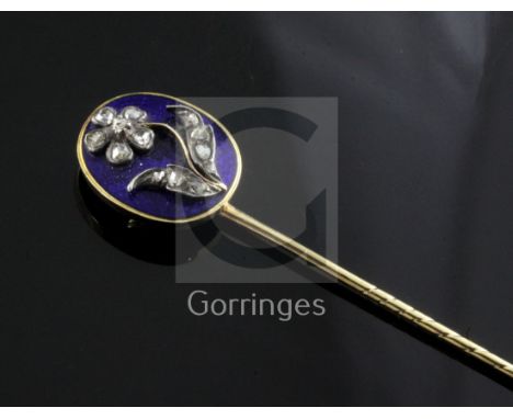 A late Georgian yellow metal and blue enamel stick pin, the oval head set with rose diamonds in a flower motif and with hairp