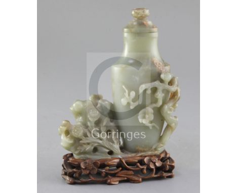 A Chinese celadon jade vase, 20th century, carved in high relief and openwork with prunus, rockwork and peonies, the stone wi