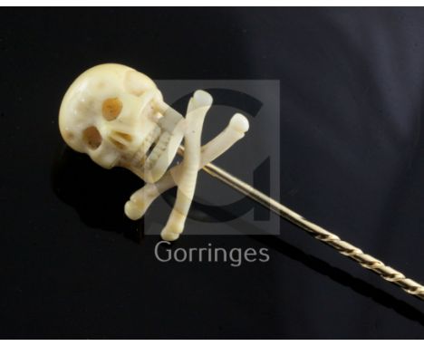 A Victorian gold stick pin with ivory skull and crossbones terminal, 75mm.