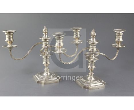 A pair of 1970's silver two branch three light dwarf candelabra, by Barker Ellis Silver Co, with reeded scroll arms and flamb