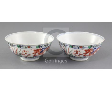 A pair of Chinese doucai 'dragon' bowls, late 19th/early 20th century, each painted with dragons and phoenix amid foliage, be