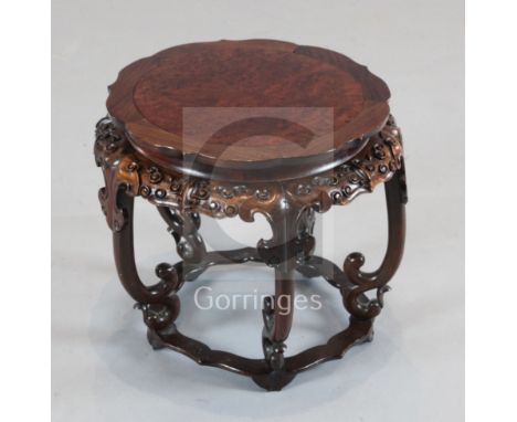 A Chinese hongmu and burr wood stand, early 20th century, the petal shaped frieze carved with taotie masks, on five scroll su
