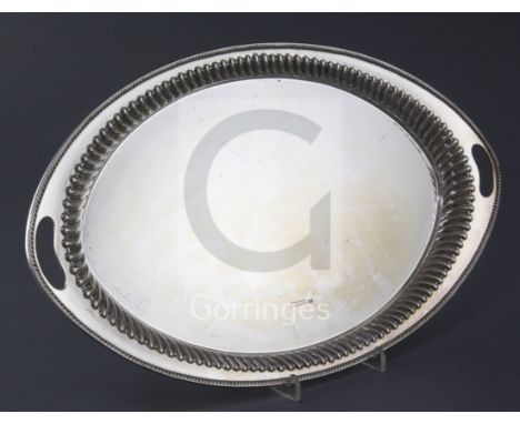 A Victorian silver oval tray by Harrison Brothers and Howson, with inset handles and fluted border, Sheffield, 1886, 46cm, 29