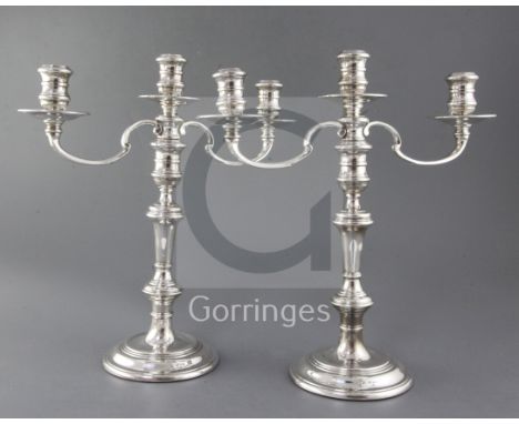 A pair of late 1970's silver two branch three light candelabra by William Comyns & Sons Ltd, with scroll arms and turned wais