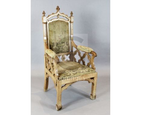 A Victorian Gothic revival oak armchair, with tapestry upholstered back, arms and seat, and carved and pierced frame, W.2ft 2