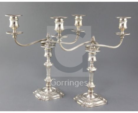 A pair of late 1960's silver two branch, two light candelabra by James Dixon & Sons, with reeded scroll arms and flambe finia