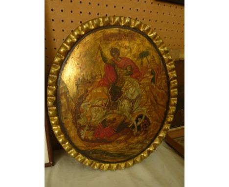 A 19th century Eastern European icon of oval form on a wooden panel with painted and gilded decoration of St. George defeatin