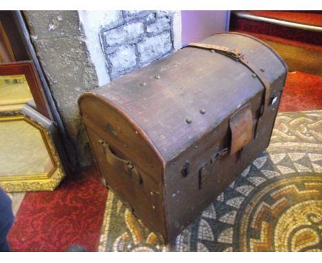 A vintage brown fibre and leather reinforced domed top travelling trunk with applied diamond shaped label depicting a stork i