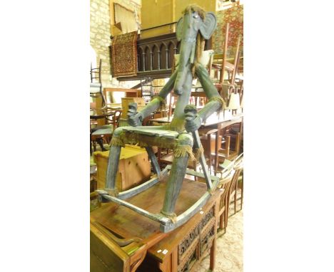 An unusual large/outsized Indonesian hardwood rocking chair, the raised back in the form of an elephant's head and trunk with