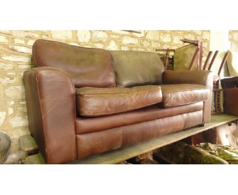 A contemporary tan leather upholstered two seat sofa with swept slab arms and loose cushions (The Vintage Tanning Co by Halo)