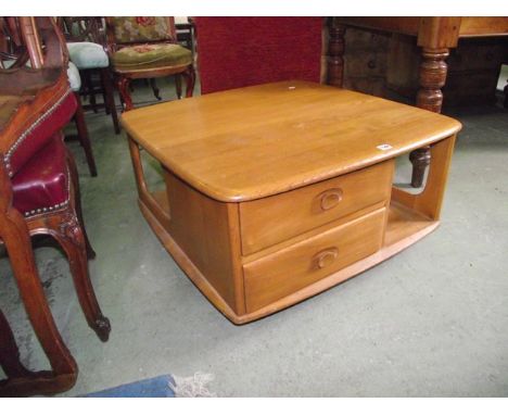 An Ercol light elm 'Pandora's Box' coffee table with moulded outline, fitted with two drawers and open segmented compartments