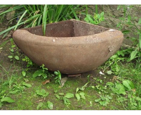 A small vintage cast iron wall mounted corner feeding trough