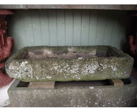 A weathered rough hewn natural stone trough of shallow rectangular form 110 cm long x 50 cm wide x 20 cm deep approx