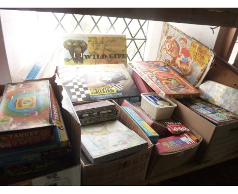 An extensive mixed collection of early 20th century jigsaw puzzles, board games, etc, to include a Scalextric set by Tri-Ang,