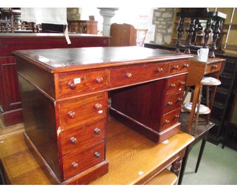 A Victorian mahogany kneehole twin pedestal desk, the rectangular top with inset green leather writing surface over the usual