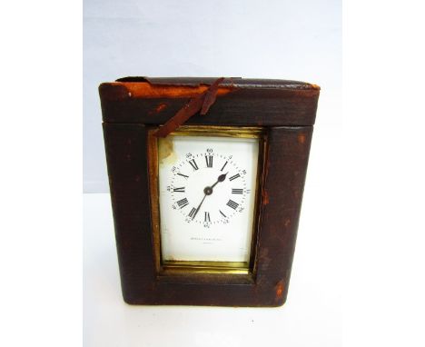 A brass carriage clock with enamel dial and 8 day time piece and case