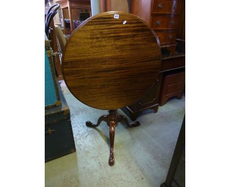 A reproduction mahogany snap top occasional table in the Georgian style, the circular top with moulded outline over a bird ca