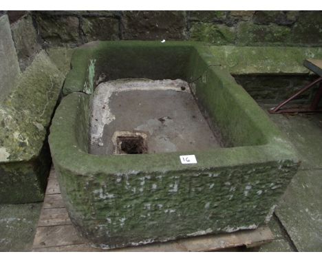 A natural stone garden trough of rectangular form, thickly walled with rounded front corners (broken), 80 x 56 cm approx