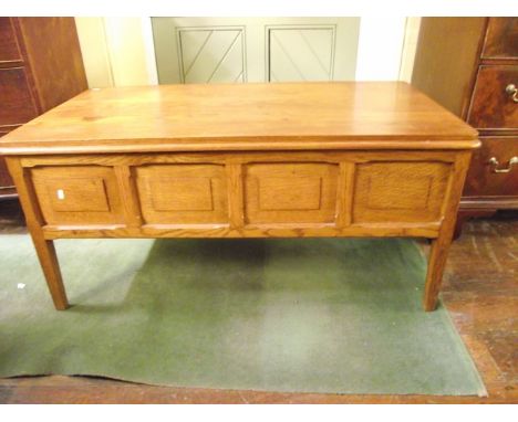 A floor standing medium to light oak storage box of rectangular form with hinged lid and moulded rectangular panelled frame r