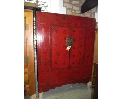 A Chinese red stained wardrobe with chinoiserie detail, enclosed by a pair of rectangular doors, the interior fitted with a c