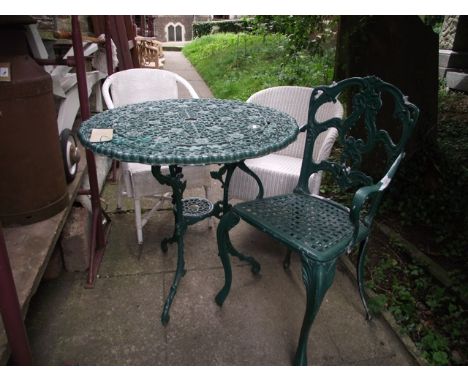A cast aluminium garden terrace table of circular form with decorative pierced and scrolled foliate detail, raised on swept t