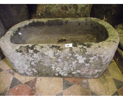 A small weathered natural stone trough of rectangular form with rounded ends, 68 cm long x 38 cm wide approx