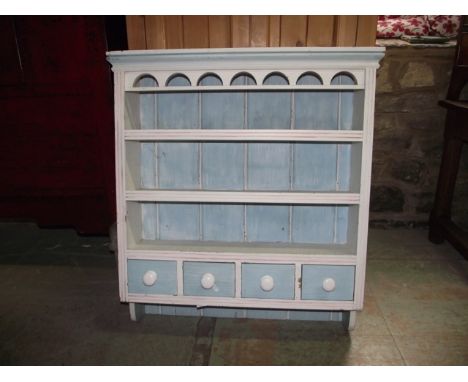 A small pine kitchen hanging plate rack with later painted finish, the moulded frame with fixed open shelves over a frieze of