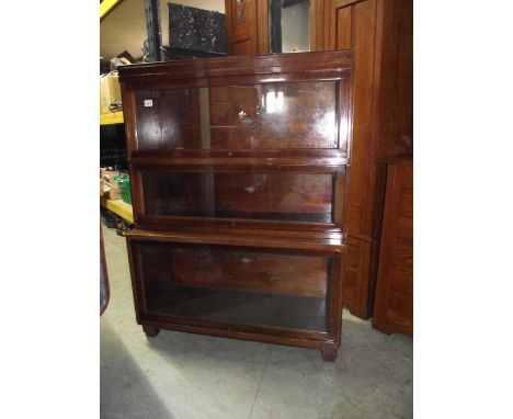 A Globe Wernicke floor standing three sectional library bookcase with up and over rectangular glazed panelled doors
