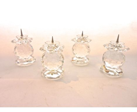 A set of four Swarovski crystal candle stands, each in the form of a faceted globe raised on an octagonal base with cut flora