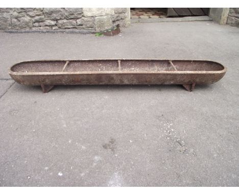 A small vintage cast iron feeding trough of slender rectangular form with rounded ends, 4ft long approx