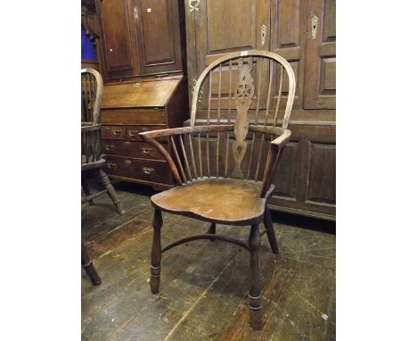 A Windsor elm, ash and beechwood hoop and stick back elbow chair with central pierced wheel splat over a saddle shaped seat a