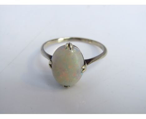 A gem-set ring, probably opal, mounted in white metal, size T 1/2