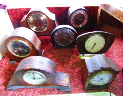 A small oak mantel clock with eight day timepiece and carved oak framework together with six other various mantel clocks (7)