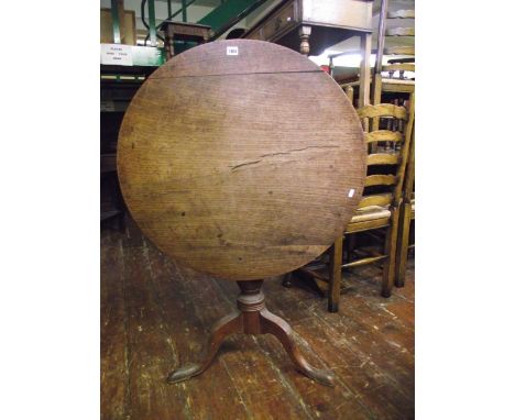 A Georgian oak snap top occasional table of circular form raised on a turned vase shaped pillar and tripod 