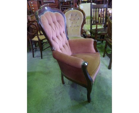 A reproduction Victorian style drawing room chair with upholstered seat and button back within a shaped and moulded frame 