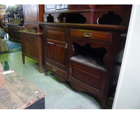 A late Victorian/Edwardian arts and crafts style mahogany sideboard, the rectangular overhanging top over an arrangement of c