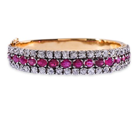 A THREE ROW RUBY AND DIAMOND BANGLE Featuring oval cut rubies, likely heated of Burmese origin, totalling approximately 8.0 C