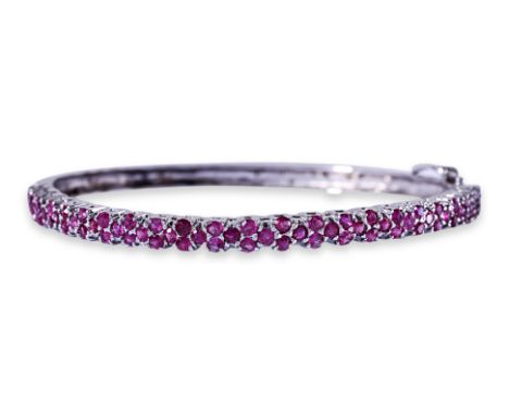 A RUBY HINGED BANGLE
Featuring round cut rubies totalling approximately 3.00 Cts, mounted in an unmarked white gold setting.
