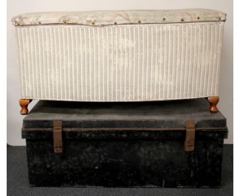 A metal cabin trunk and a Lloyd Loom ottoman.