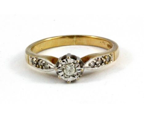 A 9ct yellow gold diamond solitaire ring with diamond set shoulders, (L.5).