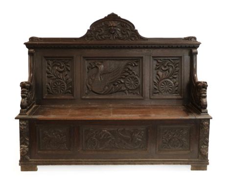 A Victorian Carved Oak Hall Bench, 3rd quarter 19th century, the back support with a scrolled pediment carved as a Green Man 