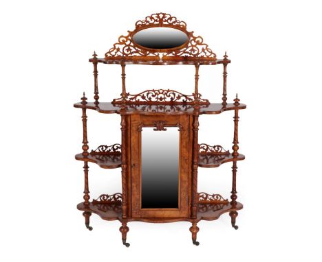 A Victorian Burr Walnut Whatnot, circa 1870, of graduated form with an oval moulded frame above a serpentine shaped shelf wit