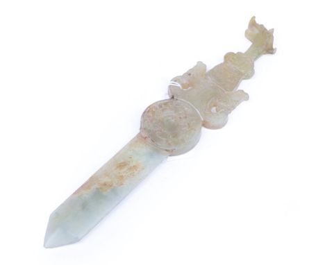 A Chinese Jade Knife, of archaic form, with mask and scroll handle, circular boss and geometric blade, 25cm long